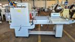 L-shaped packaging sealer with semi-automatic shrink tunnel.